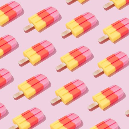 Pattern of colorful ice cream popsicle on pastel pink background