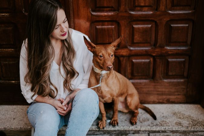 Woman with purebred dog on stone porch