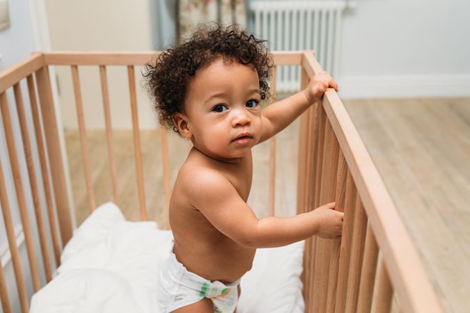 Inquisitive baby boy in crib