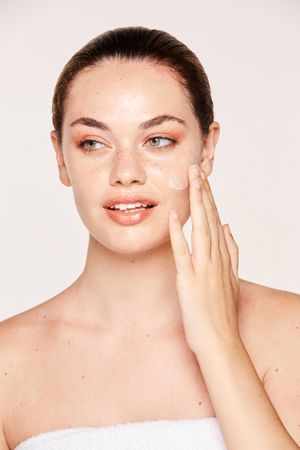 Amiable female taking care of face