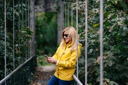 Happy female traveler taking selfie on suspension bridge in summer
