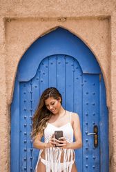 Smiling woman in beach clothes with phone