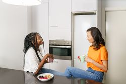 Two women talking and having breakfast in the kitchen