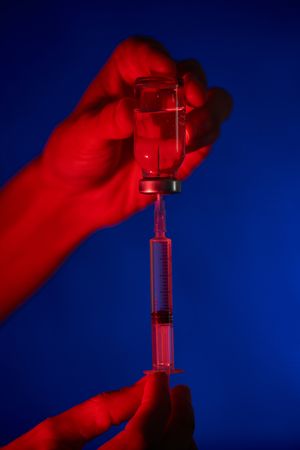 Crop doctor filling syringe with vaccine