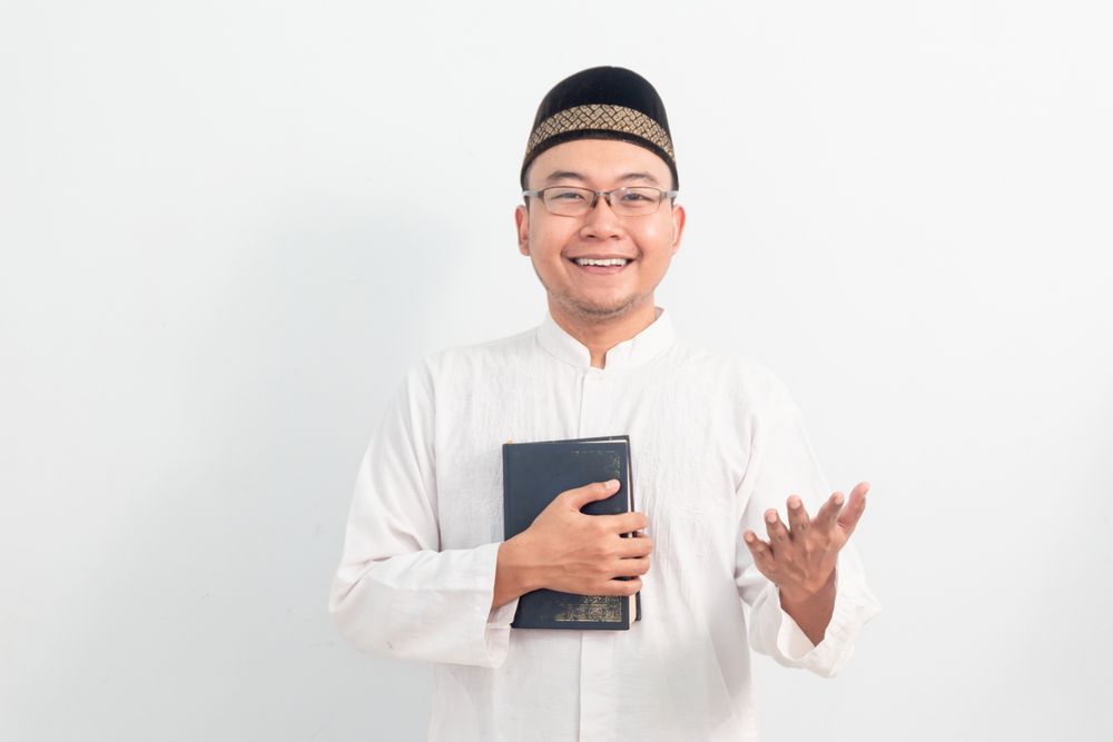 Asian Muslim man welcoming and holding quran during Ramadan