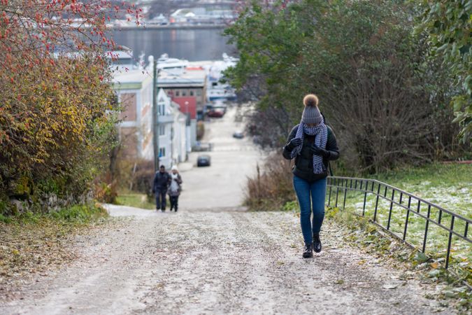 Female tourist in warm wear exploring suburbs of city