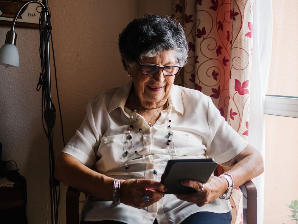 Older female reading e-book at home