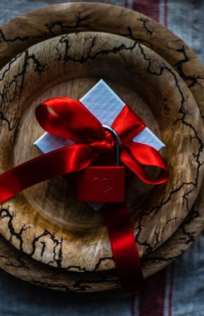 Rustic plate with ribbon wrapped present with red padlock