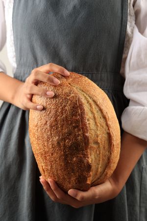 Woman Holding Freshly Baked Sourdough Bread