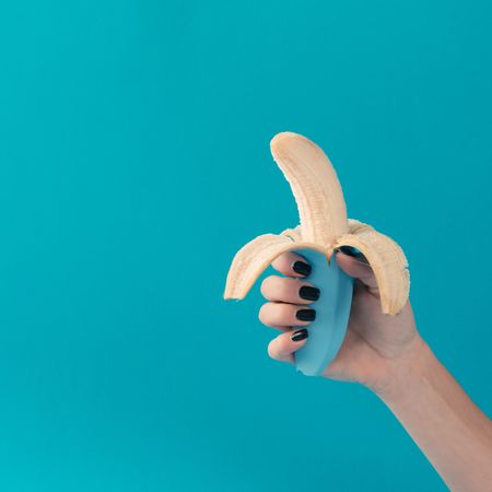 Hand holding painted blue banana