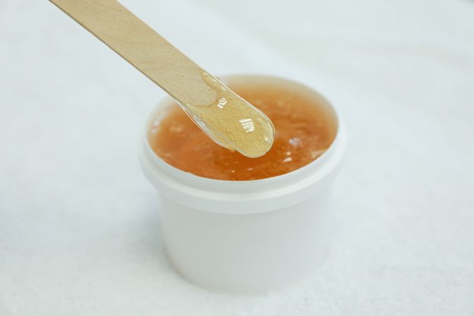 Liquid yellow paste for sugaring on plain background