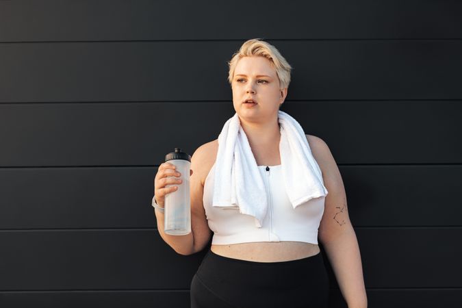 Curvy blond woman in exercise gear with water bottle