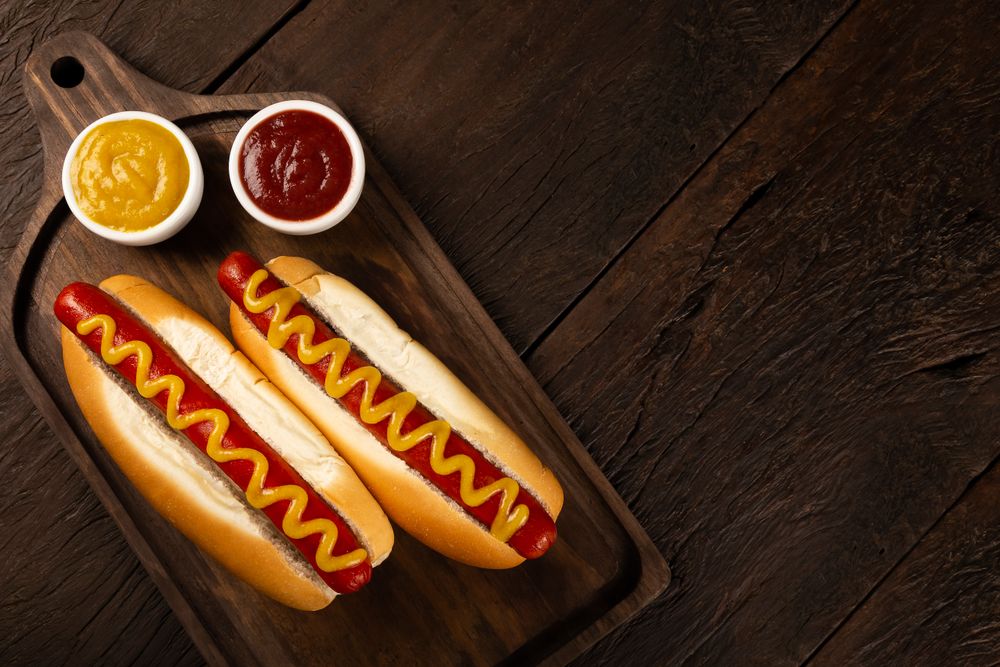 Top view of two hot dogs with mustard with copy space