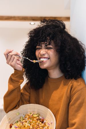Cheerful Black woman eating healthy salad