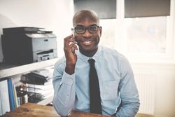Man in shirt and tie on his cellphone at home