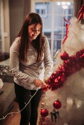 Pregnant woman arranging Christmas tree