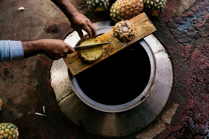Casual man cutting pineapple