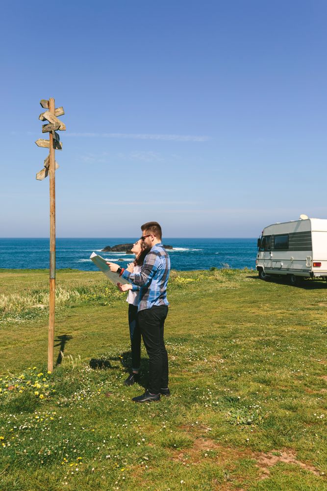 Young couple looking a map and direction sign