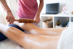 Leg of patient lying on bed during physiotherapy session in modern clinic