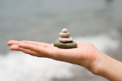 Side view of hand with small pile of rocks