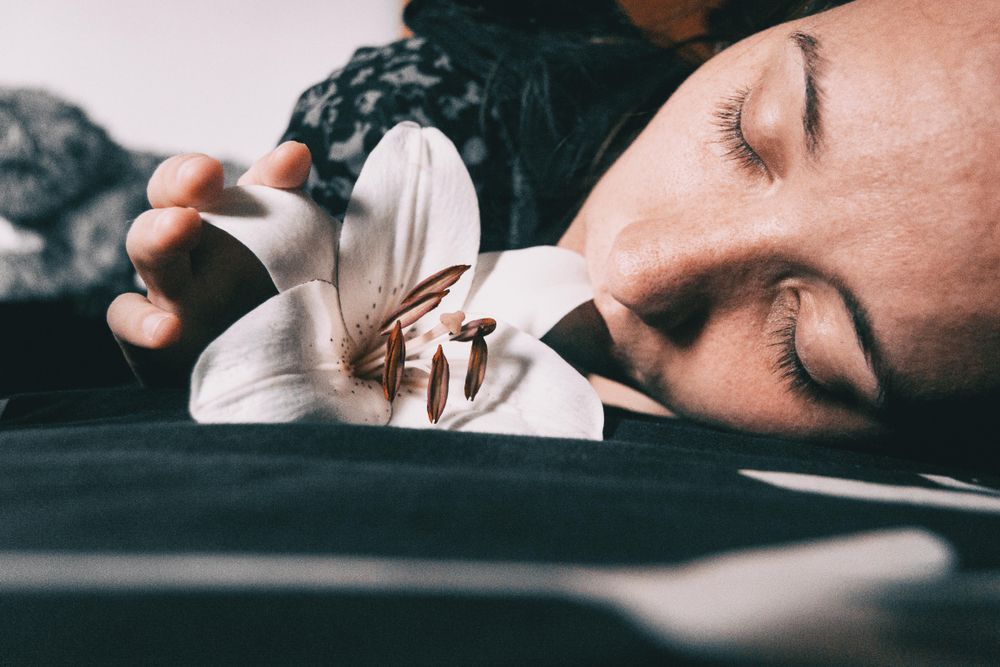 Woman laying beside lily flower