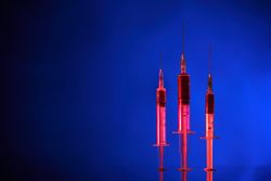 Syringes organized in row on blue background
