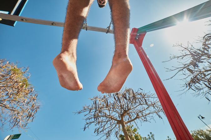 Man on swings from below