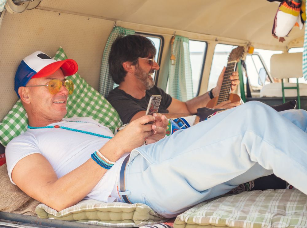 Men relaxing with mobile phones in van