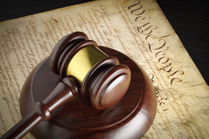 United States Constitution and Gavel Resting on Table.