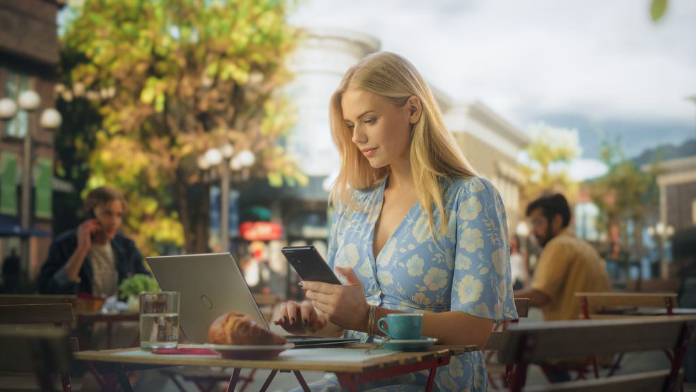 Remote Job Specialist Multitasking Company Management Assignments in an Outdoor City Cafe