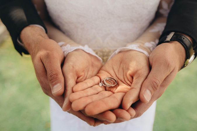 Close up of two wedding rings on bride and groom's palms