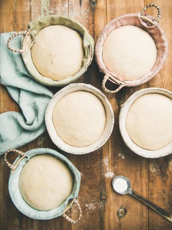 Top view of multiple baskets of bread dough