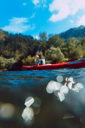 Young female kayaking on nature background
