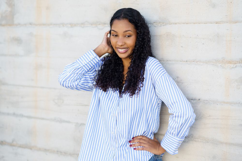SelfAssured Young Woman Posing Gracefully Against a Contemporary Concrete Wall Background