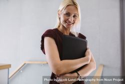 Businesswoman standing in the office holding file 5lVPA7