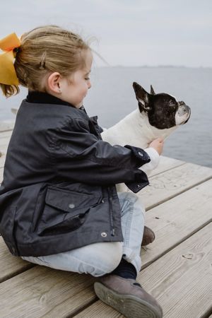 young girl with dog on pier