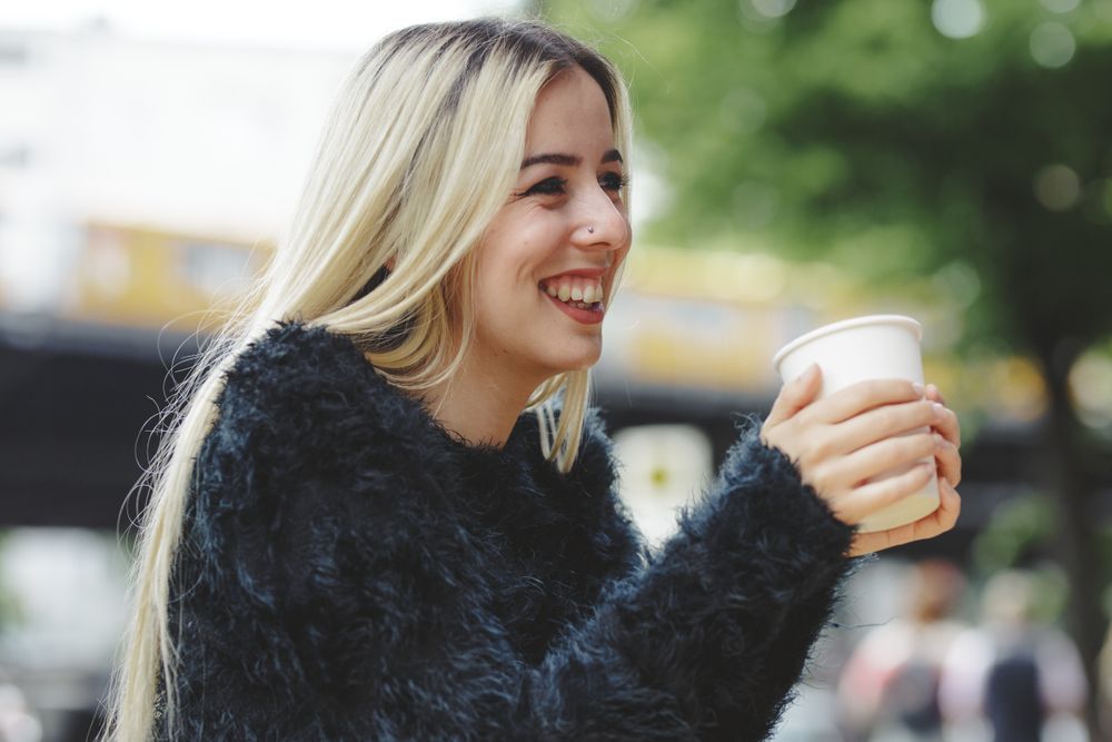 woman drinking coffee in street cafe