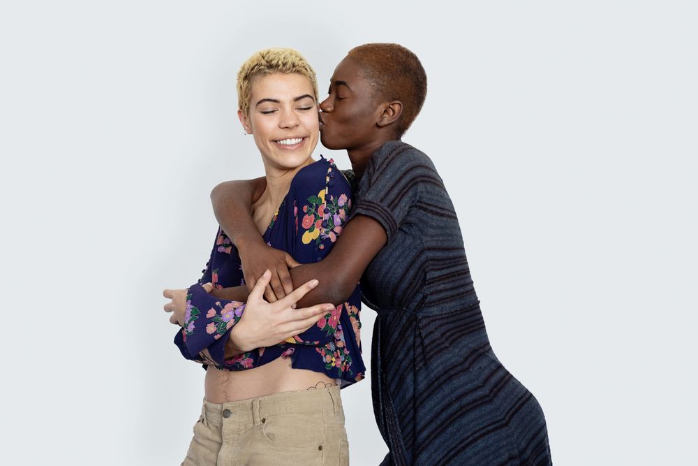 Smiling female couple embracing in studio