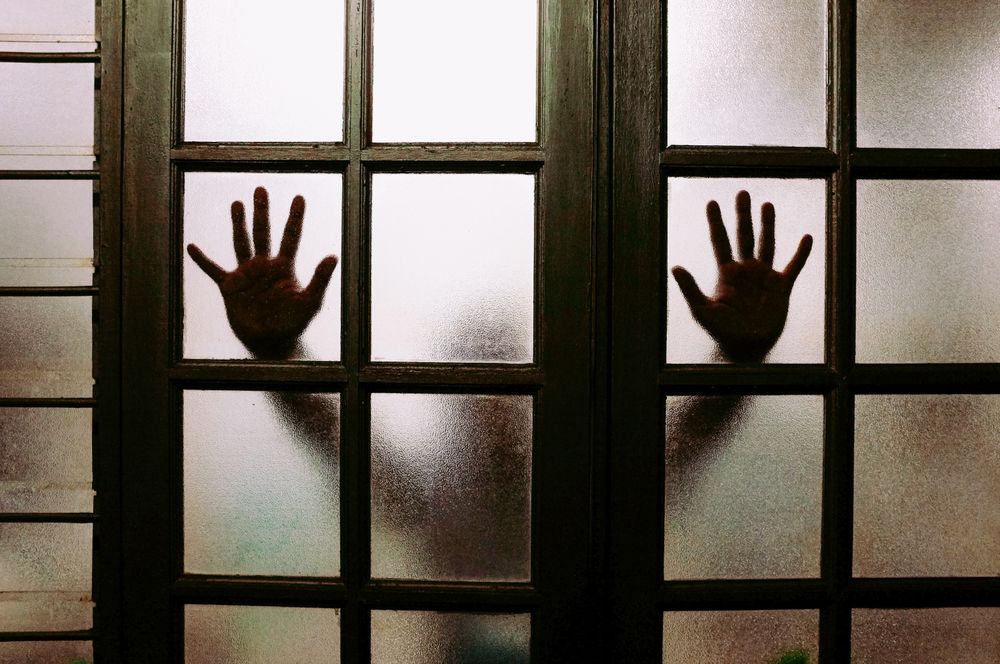 Outline of a person leaning on a window