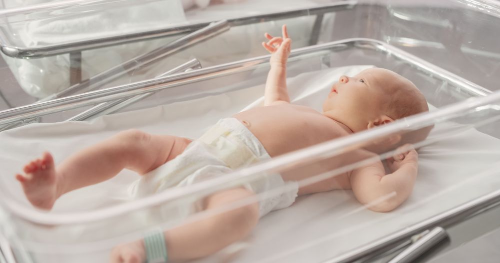 Adorable Small Newborn Child Lying in Hospital Bed in a Nursery Clinic.