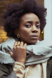 Woman wearing gray scarf and gold ring