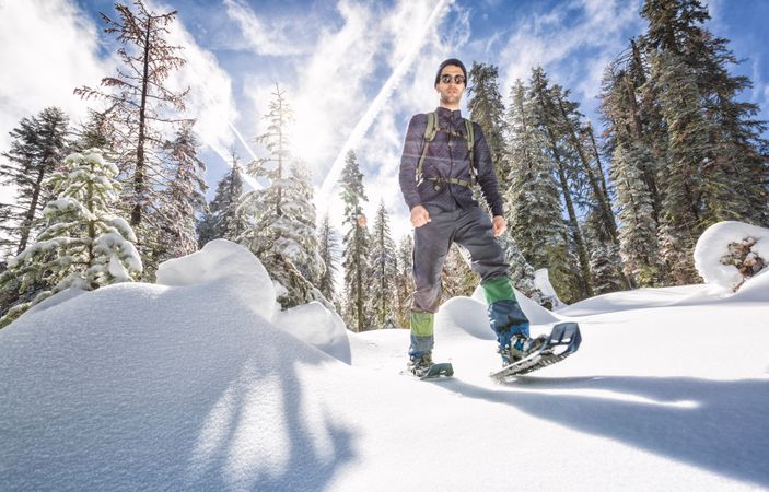 Confident young man trekking in snowshoes over snow in Yosemite California