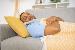 Young man with the flu napping on the living room sofa