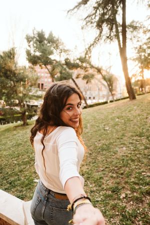 Cheerful woman leading way on city street