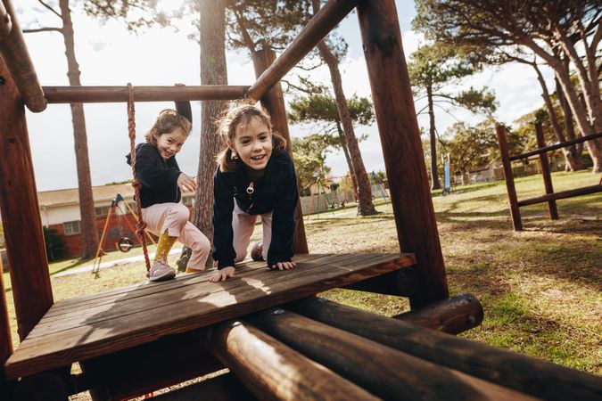 Two little girls playing at playground outdoors
