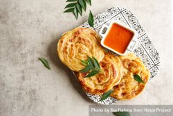 Top view of plate of roti parata or roti canai with dipping sauce bELjM4