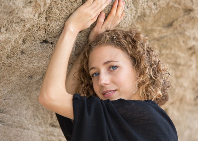 Young woman posing near stone