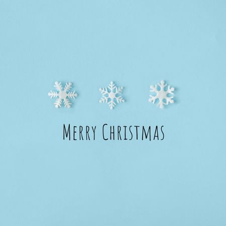 Row of snowflakes on blue background with “Merry Christmas”