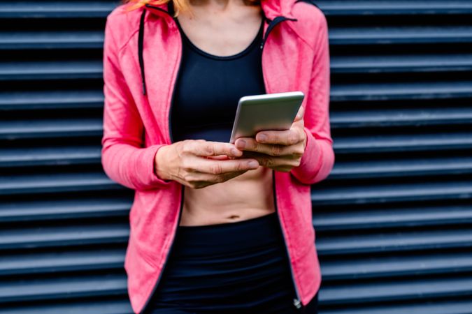 Unrecognizable female athlete with mobile phone