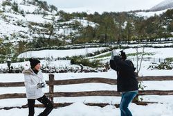 Couple having fun with snow in rural landscape